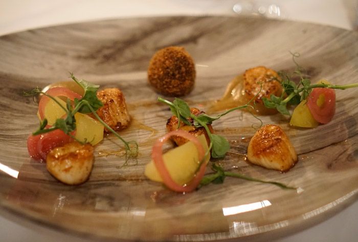 Seared scallops with black pudding, apple, cider dressing, and pickled shallots